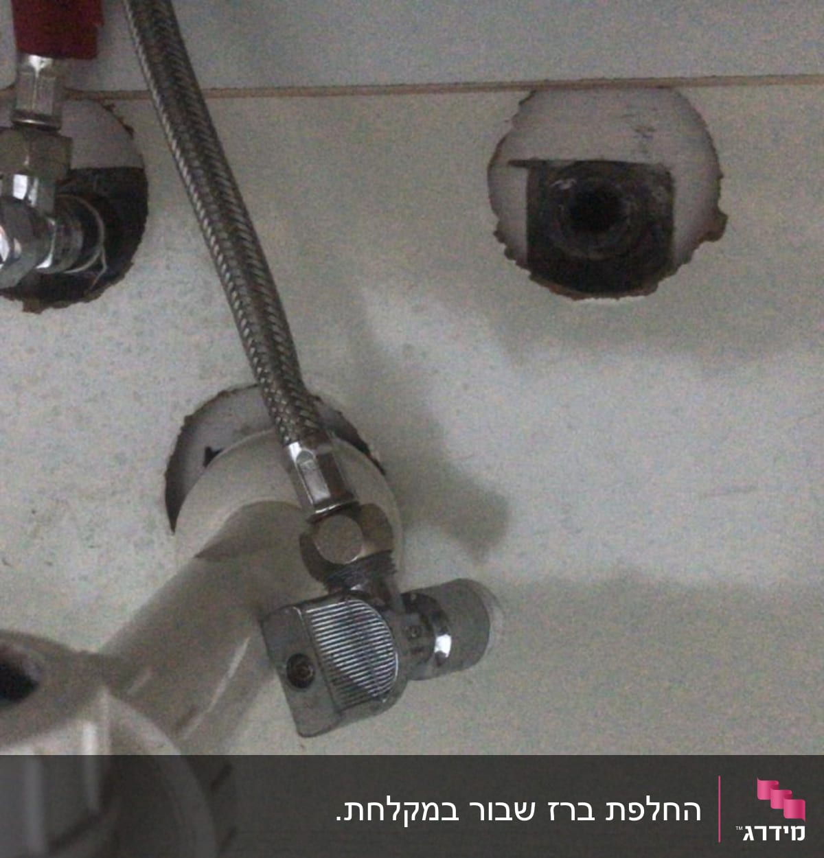 צינור מתכת וברז מתכת מתחת לכיור